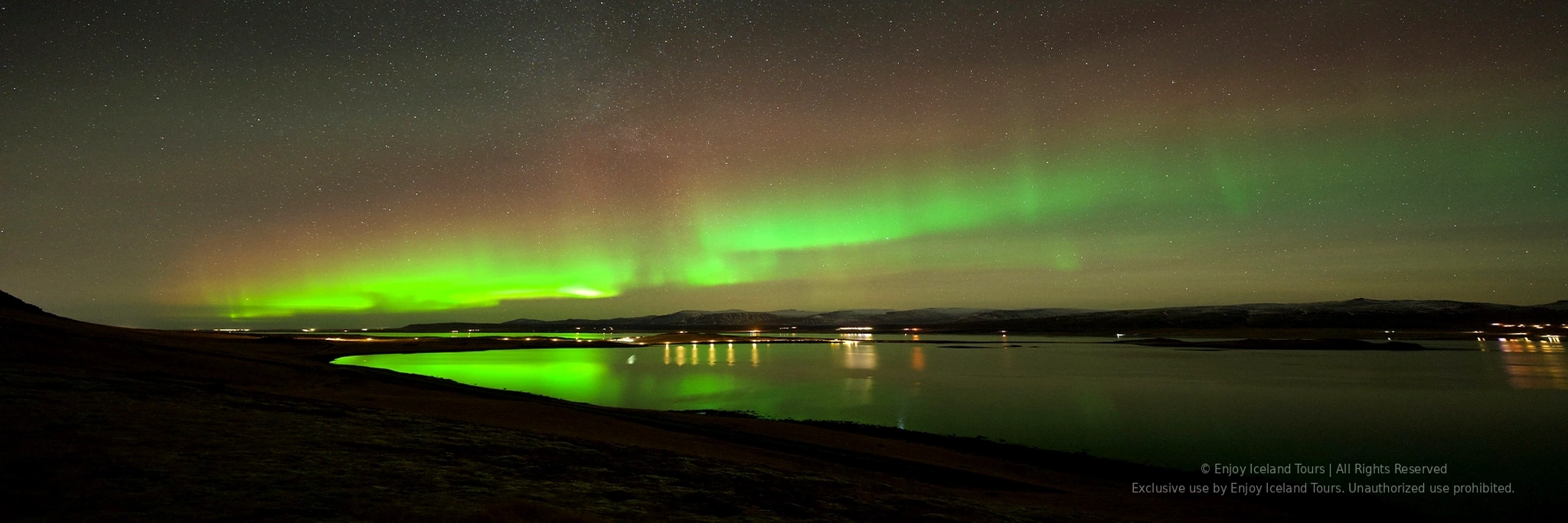 Couple watching the Northern Lights from Reykjavik